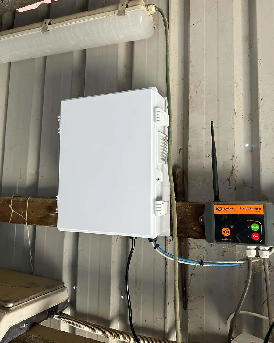 A white equipment enclosure for CCTV gear mounted inside a farm shed